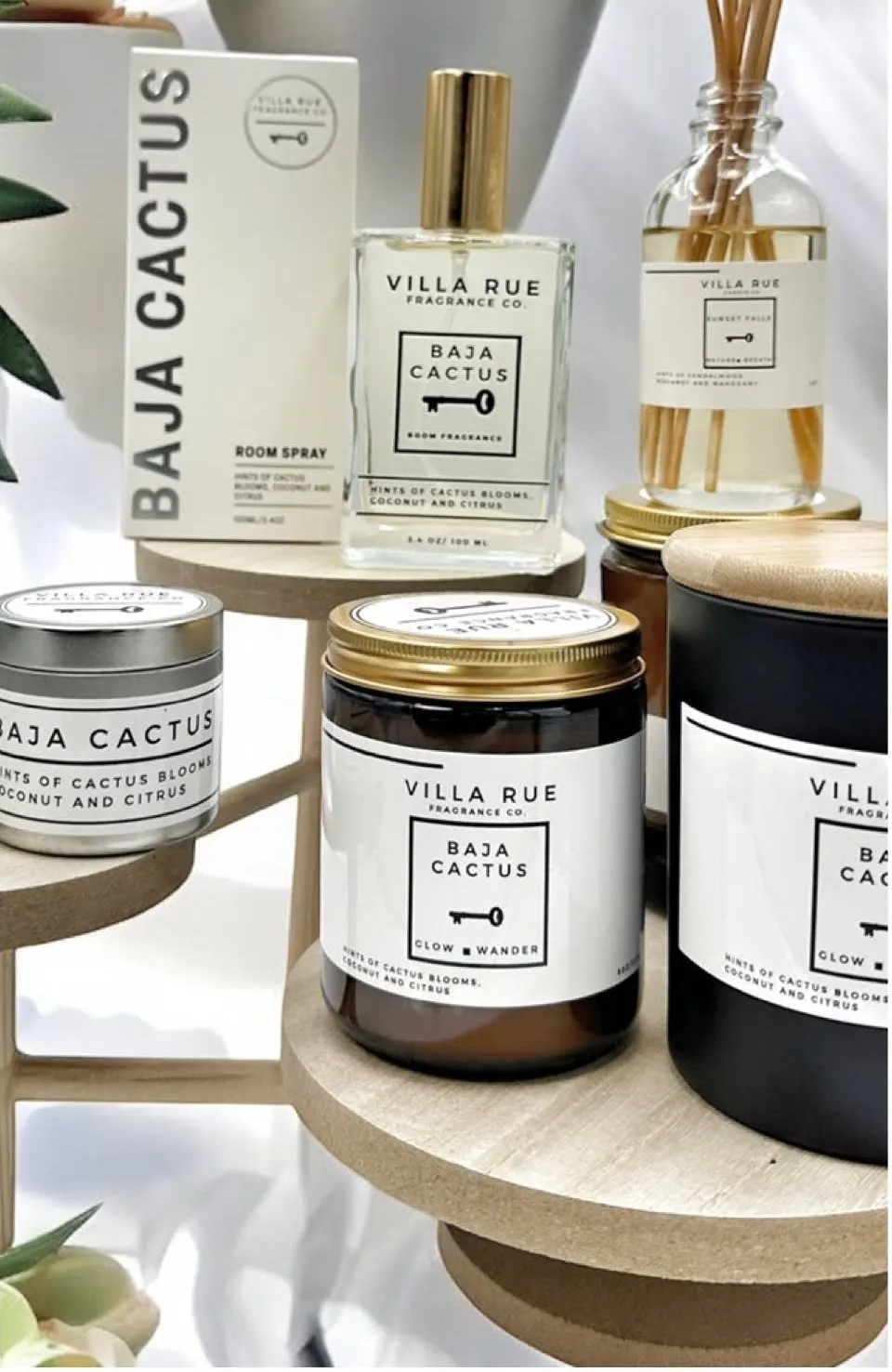 The Villa Rue collection — hand-poured candles, room mists and reed diffusers glowing on dark shelving